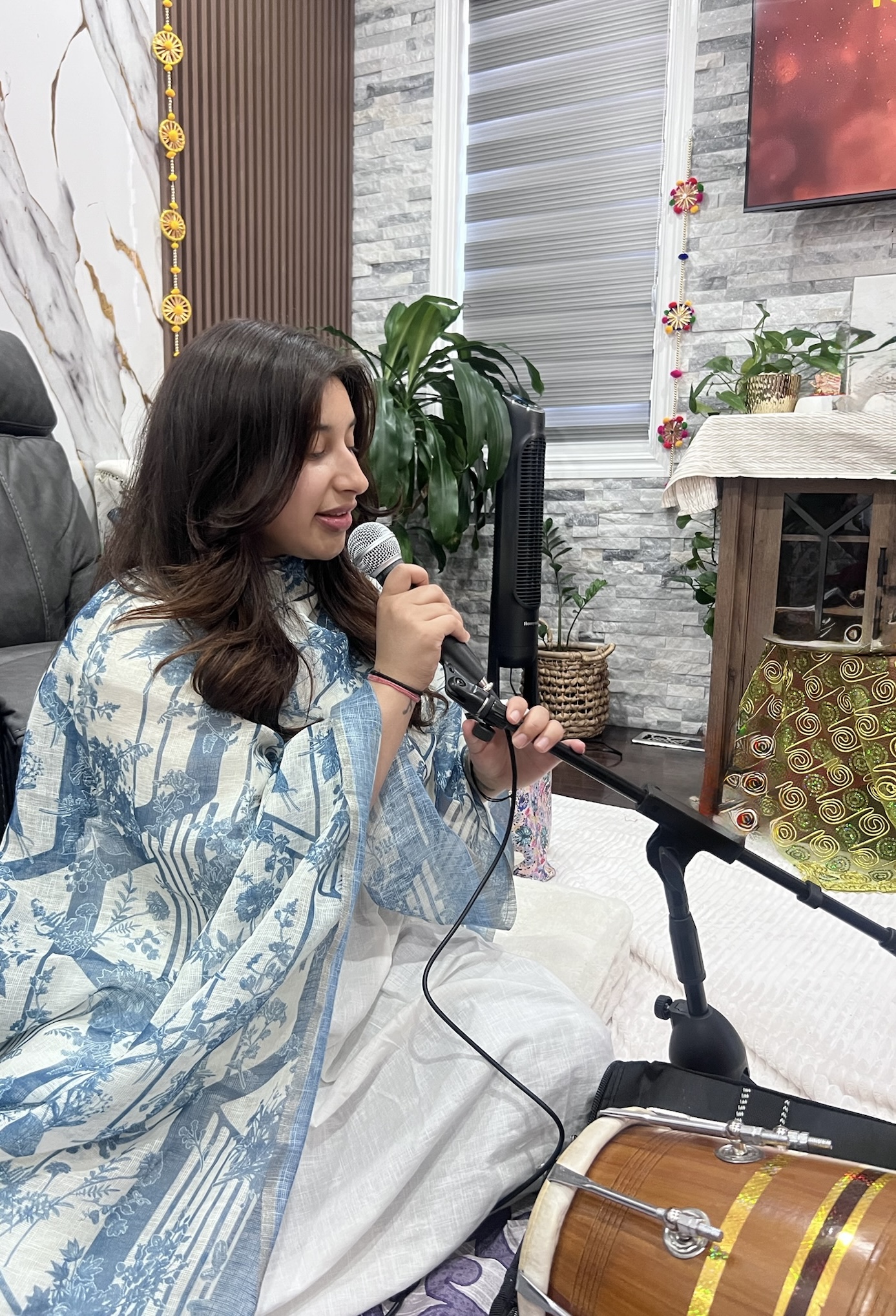 Manvi Thakur singing at a home session with dholak
